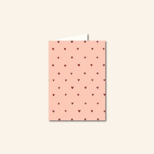 "Roze A6-wenskaart met hartjesmotief, blanco binnenkant" "Liefdevolle roze wenskaart met hartjes, geschikt voor elke gelegenheid" "Romantische A6-kaart in het roze met hartjesdesign" "Roze kaart met hartjes voor Valentijn, verjaardag of zomaar" "Wenskaart A6, roze met hartjes, op rood oppervlak" 